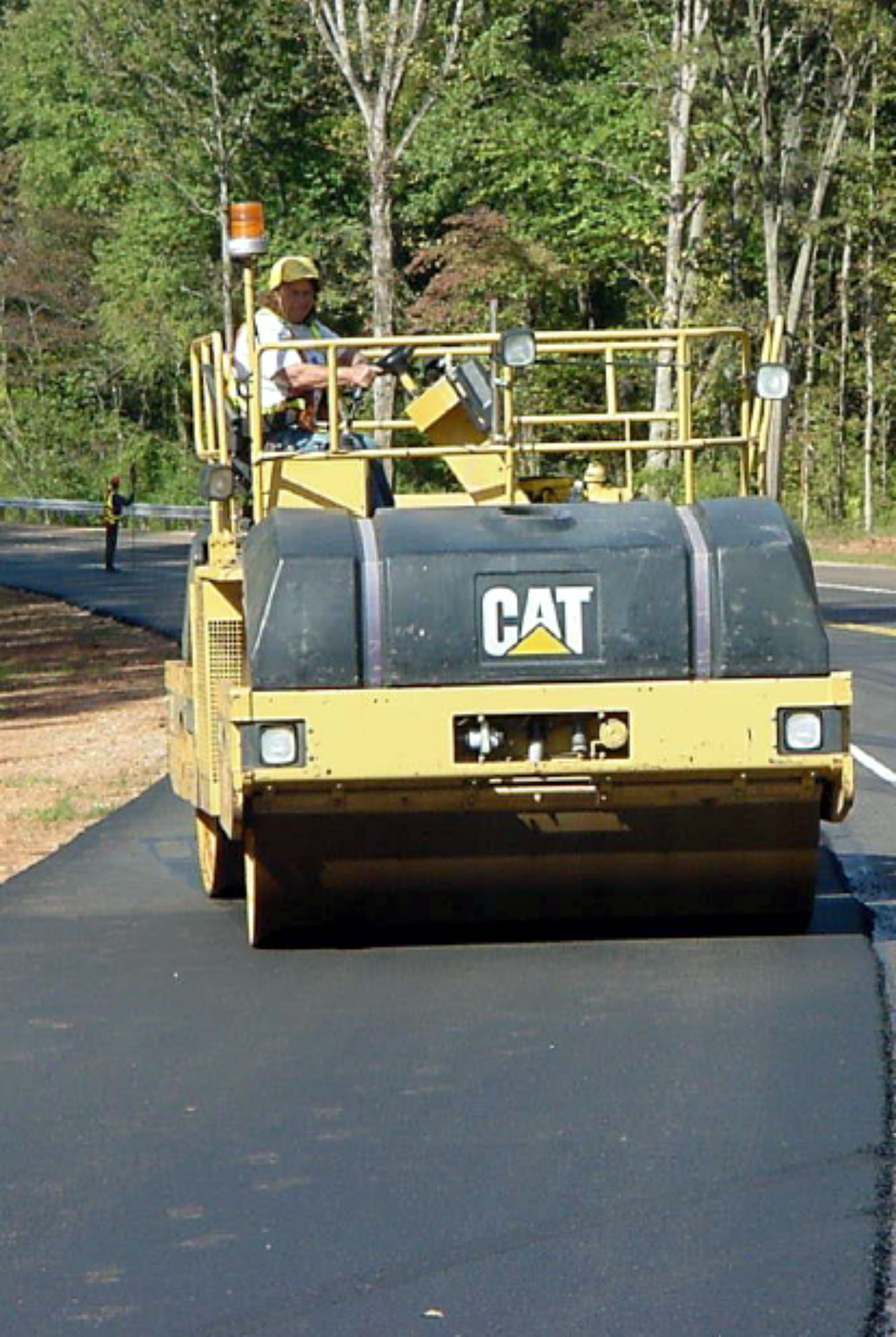 Compaction roller finishing a freshly paved asphalt roadway